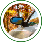 A car parked near colorful fall foliage.